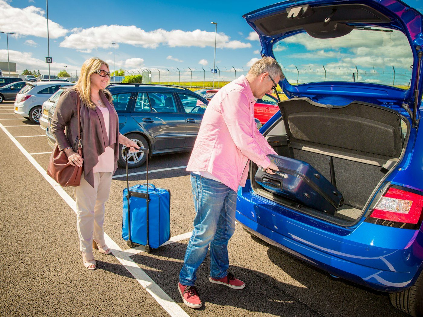 Couple loading luggage into their car for a trip